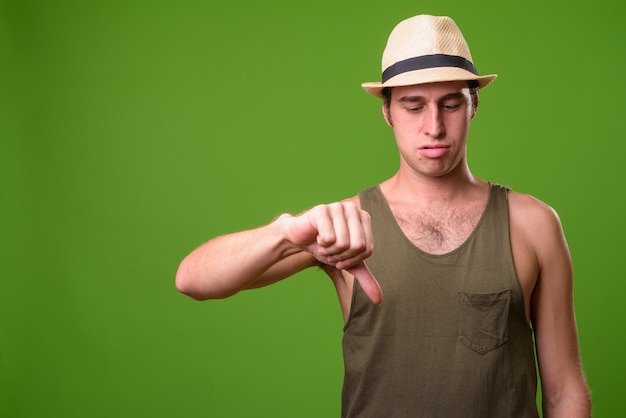 Hombre joven turista contra la pared verde