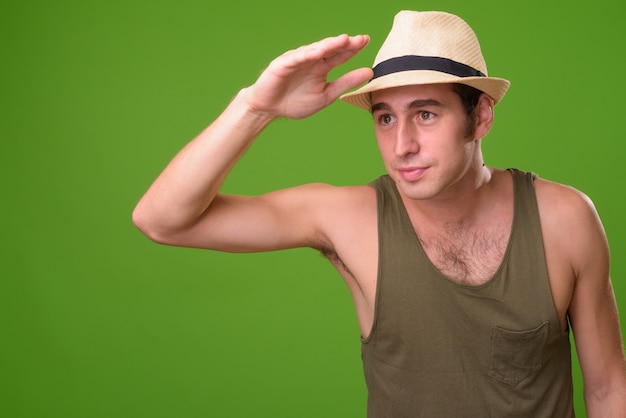 Hombre joven turista contra la pared verde