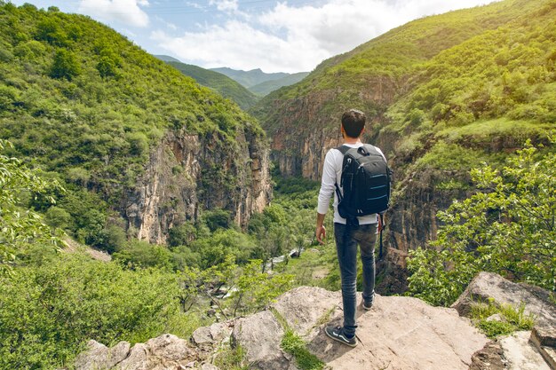 Hombre joven viajero feliz en rocas