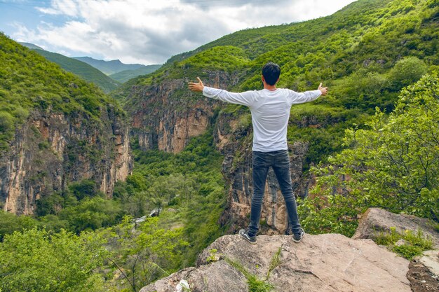 Hombre joven viajero feliz en rocas