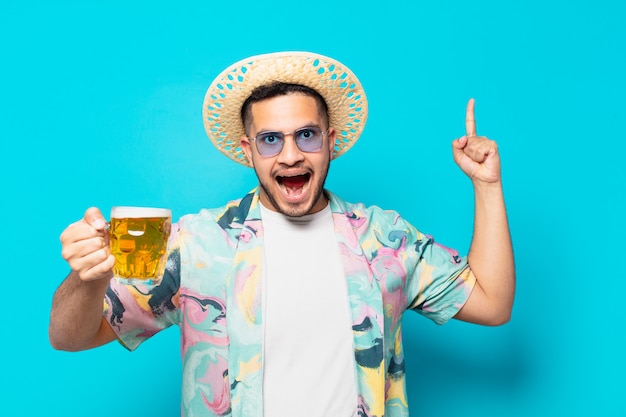 Hombre joven viajero hispano celebrando una victoria exitosa y sosteniendo una cerveza