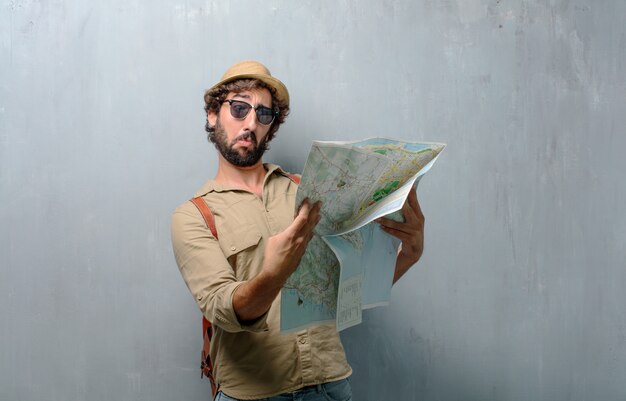 Hombre joven viajero con un mapa y bolso de piel.