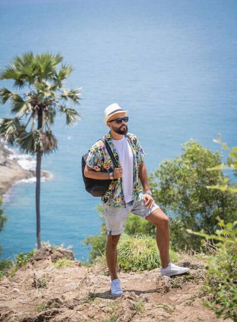 Hombre joven viajero en vacaciones de verano con hermosas montañas y paisajes marinos en el fondo