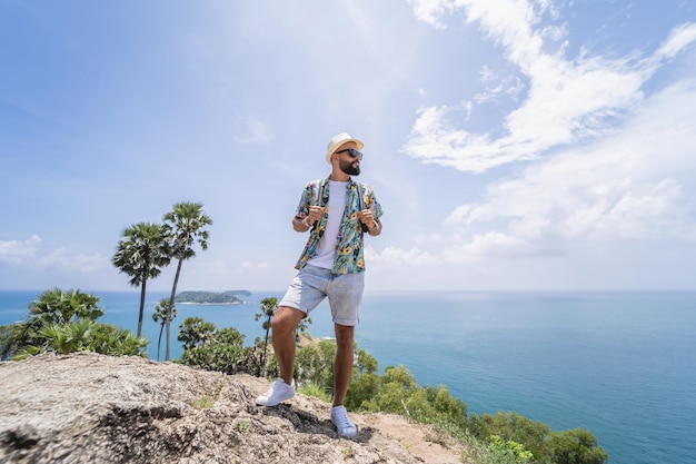 Hombre joven viajero en vacaciones de verano con hermosas montañas y paisajes marinos en el fondo