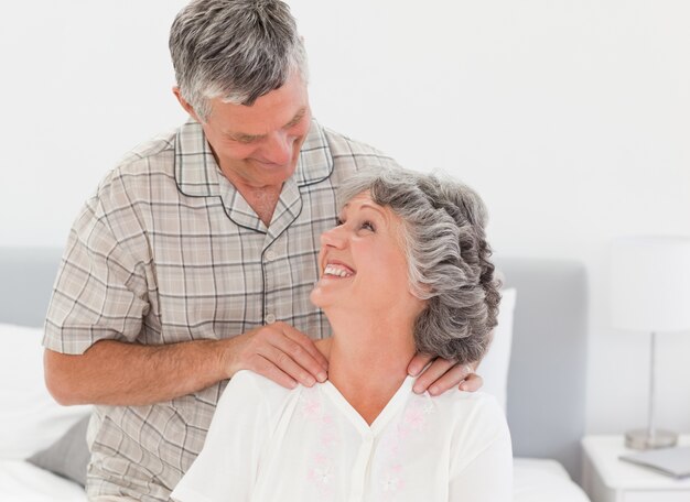 Hombre jubilado dando un masaje a su esposa