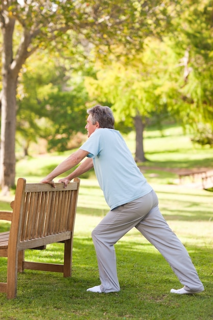 Hombre jubilado haciendo sus estiramientos en el parque