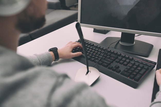 Un hombre juega en la computadora de la oficina en el momento en que tiene que trabajar