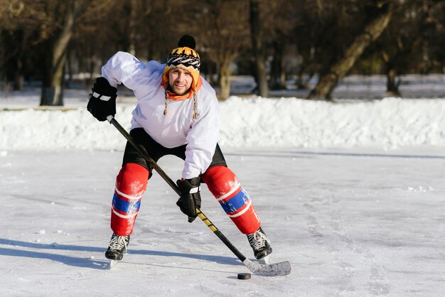 El hombre juega hockey en la pista