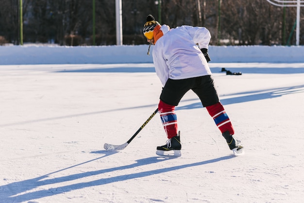 El hombre juega hockey en la pista