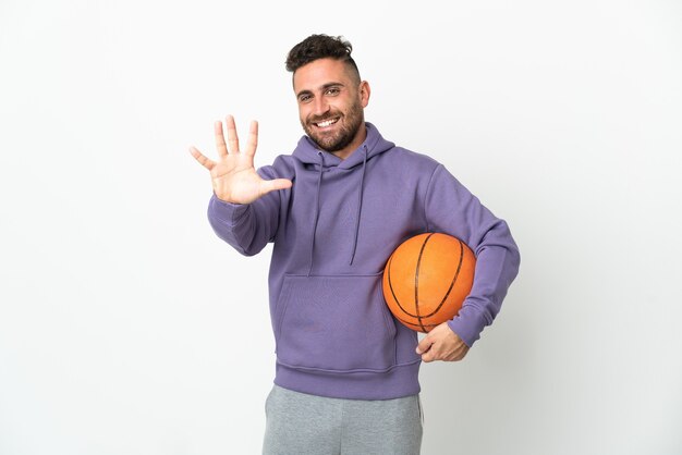 Hombre de jugador de baloncesto aislado sobre fondo blanco contando cinco con los dedos