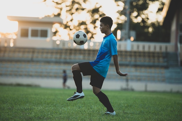 Foto hombre jugando al fútbol en el césped