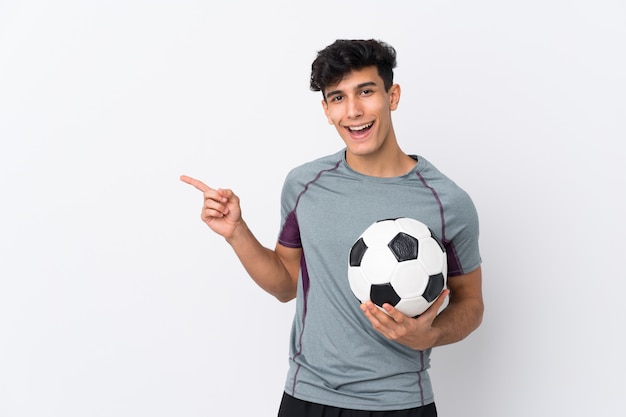 Hombre jugando al fútbol sobre pared aislada