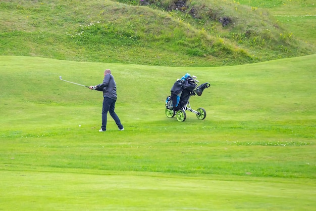 Hombre jugando al golf en un campo verde en la isla Heimaey del archipiélago Vestmannaeyjar Islandia