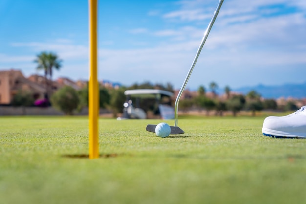 Hombre jugando al golf golpeando la pelota en el green con el putter