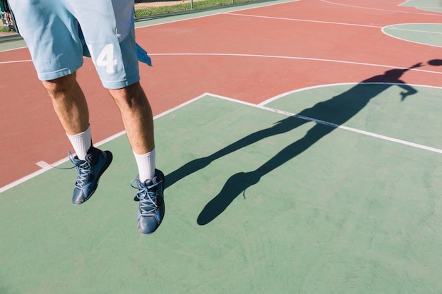 Hombre jugando baloncesto, saltando, sombra