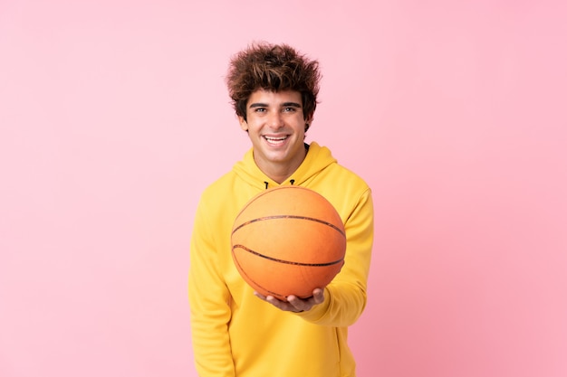 Hombre jugando baloncesto sobre pared aislada