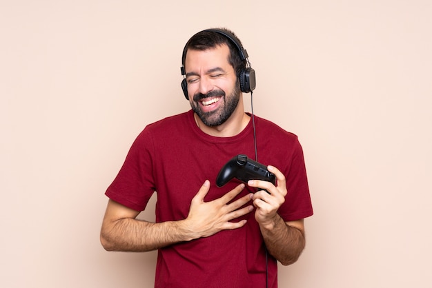 Hombre jugando con un controlador de videojuegos sonriendo mucho