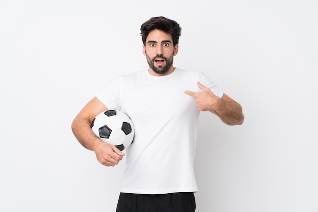 Hombre jugando fútbol sobre pared aislada