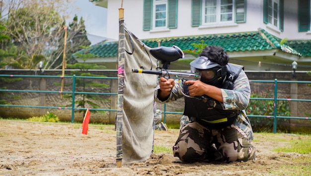 un hombre jugando a la pelota de pintura y preparándose para disparar con un arma v.2