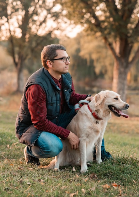 Foto hombre jugando con perro golden retriever al atardecer perro expresa emociones a su dueño al aire libre