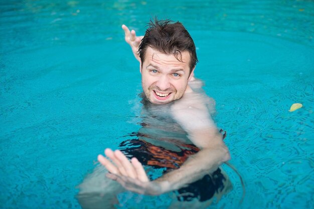 Hombre jugando en la piscina de vacaciones