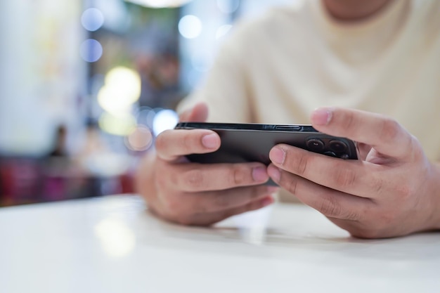 Hombre jugando en el teléfono móvil gamer boy jugando videojuegos sosteniendo Smartphone trabajando dispositivos móviles tecnología de telefonía celular concepto de comercio electrónico