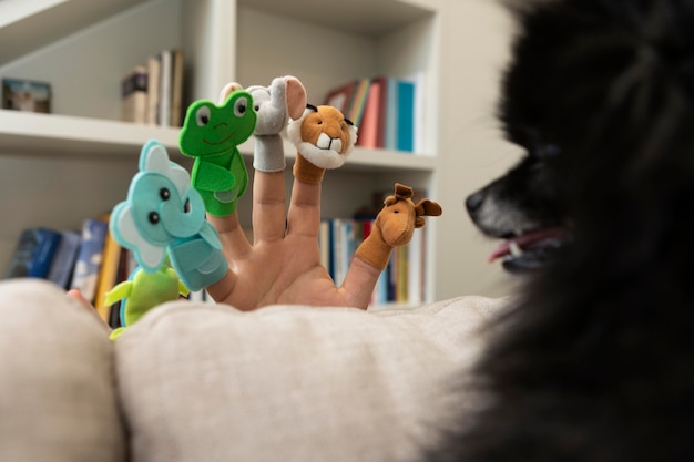 Foto hombre jugando con títeres junto a su perro