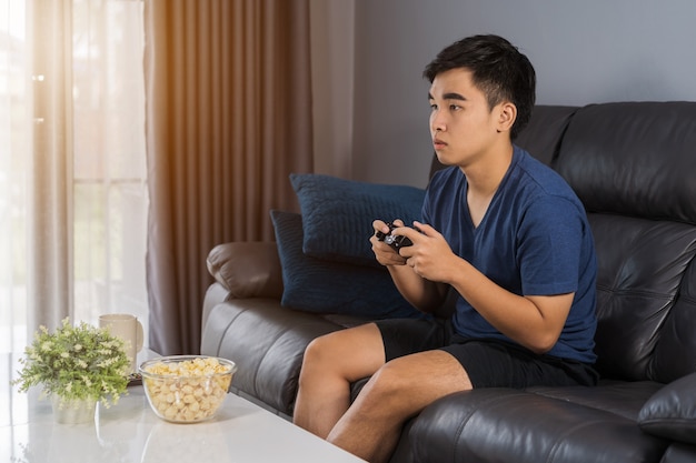 Hombre jugando videojuegos con joystick en la sala de estar