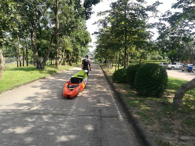 Foto hombre con kayak caminando por el sendero