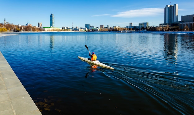 Un hombre en un kayak en un lago de la ciudad.