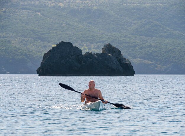 Hombre en kayak en el mar Egeo en una isla griega en un día de verano en Grecia