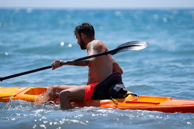 Hombre en kayak en la playa durante las vacaciones de verano