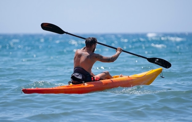 Hombre en kayak en la playa durante las vacaciones de verano