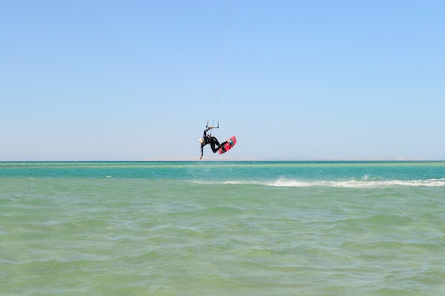 Hombre de kite surf saltar en el mar