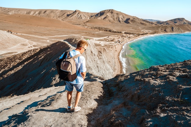 Un hombre en la ladera del cabo camaleón con una increíble vista panorámica de las colinas y el mar