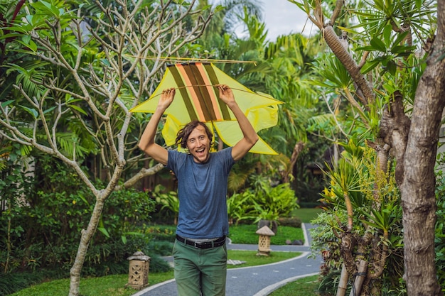 El hombre lanza una cometa en el parque de Ubud, isla de Bali, Indonesia