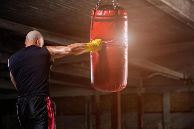 Hombre, lanzamiento, puñetazos, en, saco de boxeo