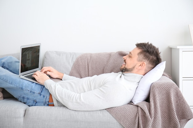 Hombre con laptop trabajando en casa