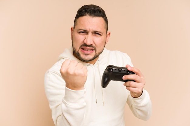 Hombre latino adulto jugando con un controlador de juego aislado