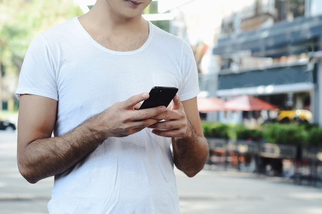 Hombre latino escribiendo en su teléfono.