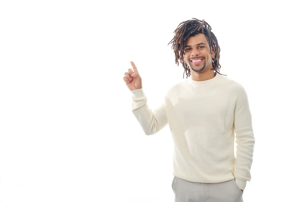 Foto hombre latino feliz apuntando con su dedo a un espacio vacío para mostrar algo mientras está de pie sobre un fondo aislado. concepto de publicidad.