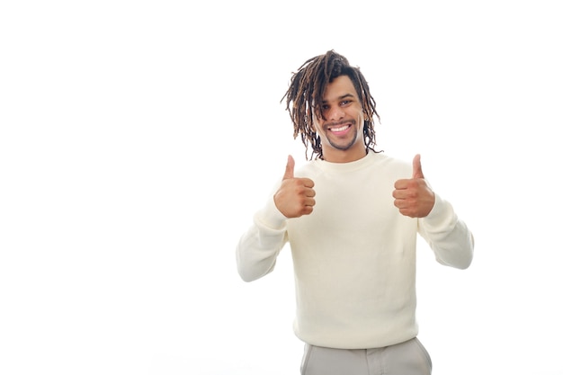 Hombre latino feliz y positivo mostrando los pulgares para arriba a la cámara mientras está de pie sobre un fondo aislado.