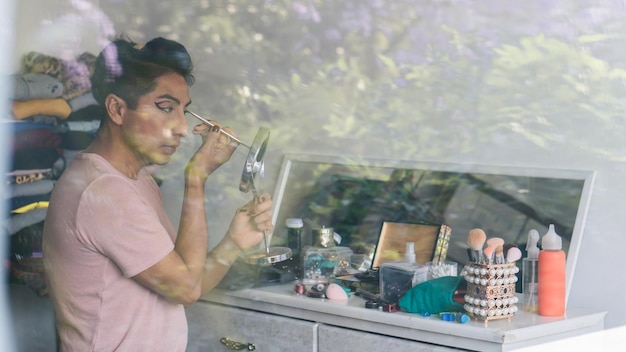 Foto hombre latino gay maquillado para trabajar. copie el espacio.