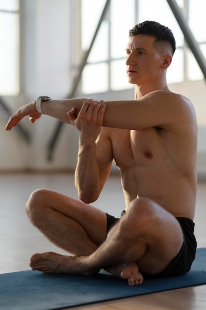 Foto hombre latino haciendo calentamiento antes de entrenar en el gimnasiotipo atractivo cuidando su cuerpo