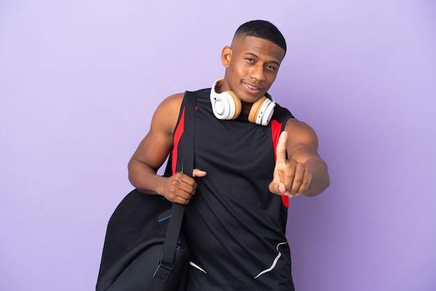 Hombre latino joven deporte con bolsa de deporte aislado