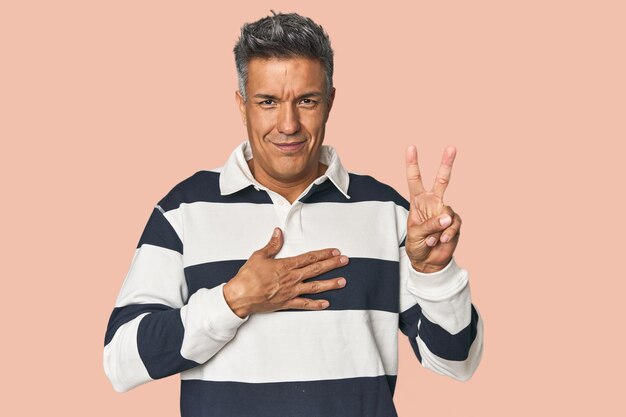 Hombre latino de mediana edad haciendo un juramento poniendo la mano en el pecho