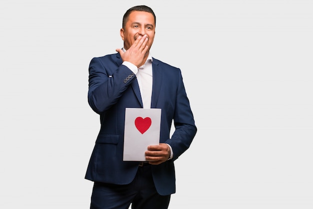 Hombre latino de mediana edad que celebra el día de San Valentín cansado y con mucho sueño