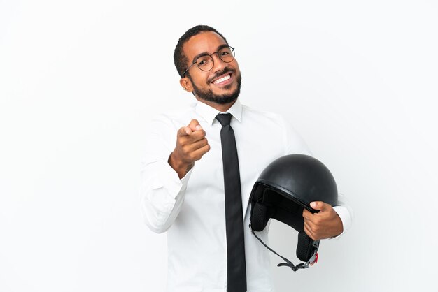 Hombre latino de negocios joven con un casco de motocicleta aislado sobre fondo blanco apuntando al frente con expresión feliz
