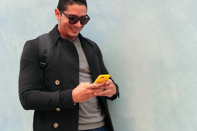 Hombre latino con smartphone en la calle