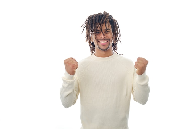 Hombre latino sonriente celebrando la victoria y el éxito mientras está de pie sobre un fondo aislado. Concepto de éxito y logro.